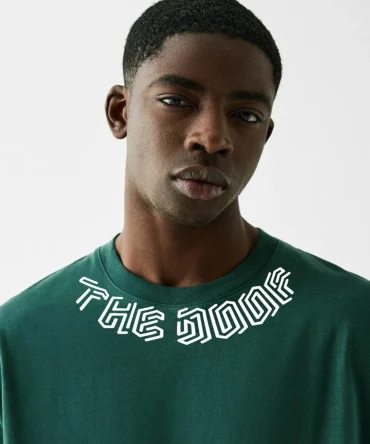 Le t-shirt GAUCHO : le luxe streetwear réinventé à Dakar. Pour les esprits libres qui apprécient le raffinement audacieux, ce vêtement mode urbaine Sénégal premium arbore « The Doof » en typographie futuriste luxueuse sur le col. Le dos affirme ta présence avec un « TD » cornu blanc imposant sur fond violet vibrant.