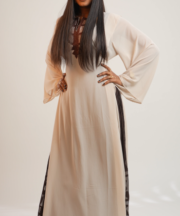 L’alliance parfaite entre légèreté et caractère. Cette robe longue d’un ton crème délicat se distingue par ses manches pagodes vaporeuses et ses empiècements latéraux en tissu texturé chocolat. Proposée en taille standard, elle offre une silhouette modulable grâce à ses liens de cintrage au dos , garantissant un ajustement sur-mesure. Une confection entièrement personnalisée est également disponible pour répondre à vos mesures spécifiques.